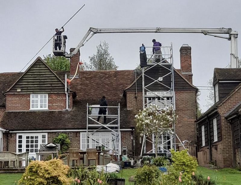 The Moss Cleaners using cherry picker and scaffolding to clean roof safely and professionally in Whitchurch, Hampshire